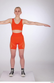 Unaisa dressed orange bike shorts orange sports bra standing t-pose…